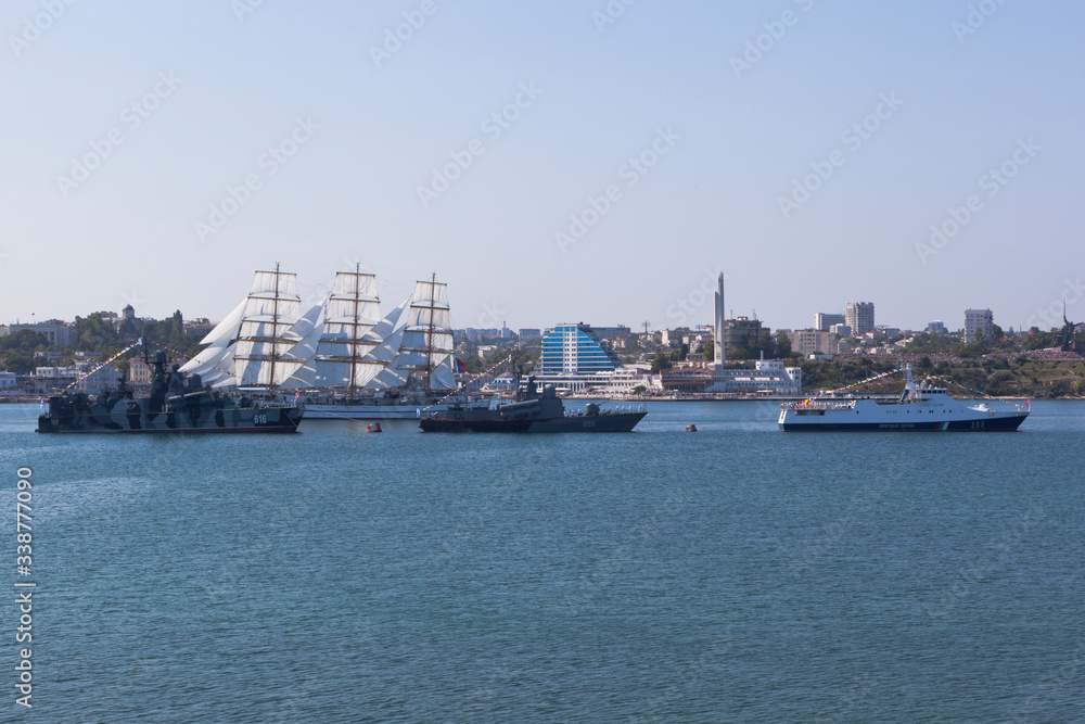 Sailboat Khersones walks along the parade of military ships at the parade on Navy Day in Sevastopol Bay, Crimea
