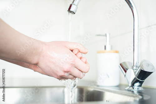Woman washing hands in kitchen