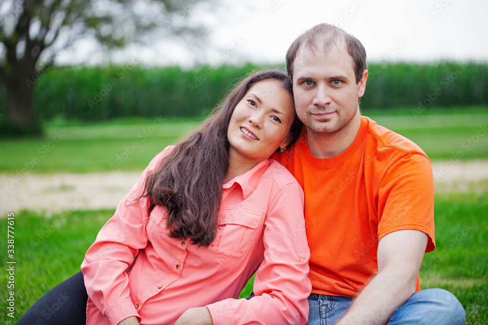 Portrait of happy young couple sitting together on grass Portrait of happy young couple sitting together on grass
