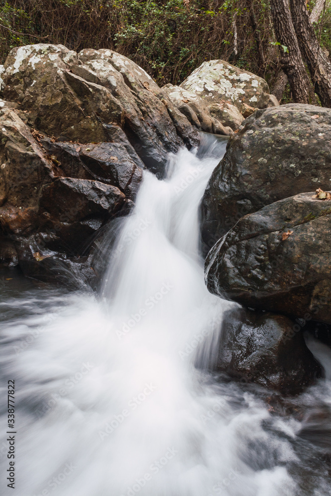Small waterfall with slow motion effect between rocks Small waterfall with slow motion effect between rocks