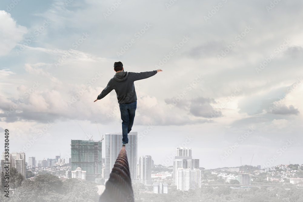 Man wearing virtual reality goggles and balancing on rope