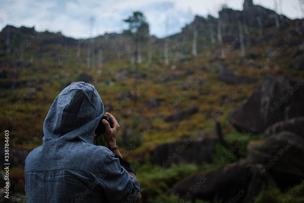 Young men photographing mountains in rainy weather.