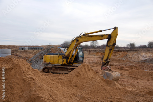 Wallpaper Mural Excavator during earthmoving at construction site. Backhoe digg ground at construction site for the construction of the road and laying sewer pipes district heating. Earth-moving heavy equipment Torontodigital.ca