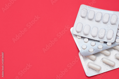 Pills blisters on red background with a copy space photo