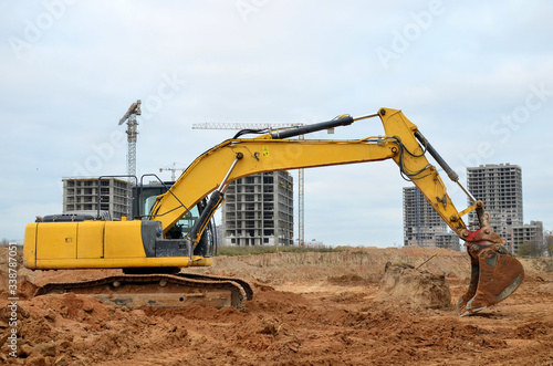 Excavator digs the ground for the foundation and construction of a new building. Road repair  asphalt replacement  renovating a section of a highway  laying or replacement of underground sewer pipes