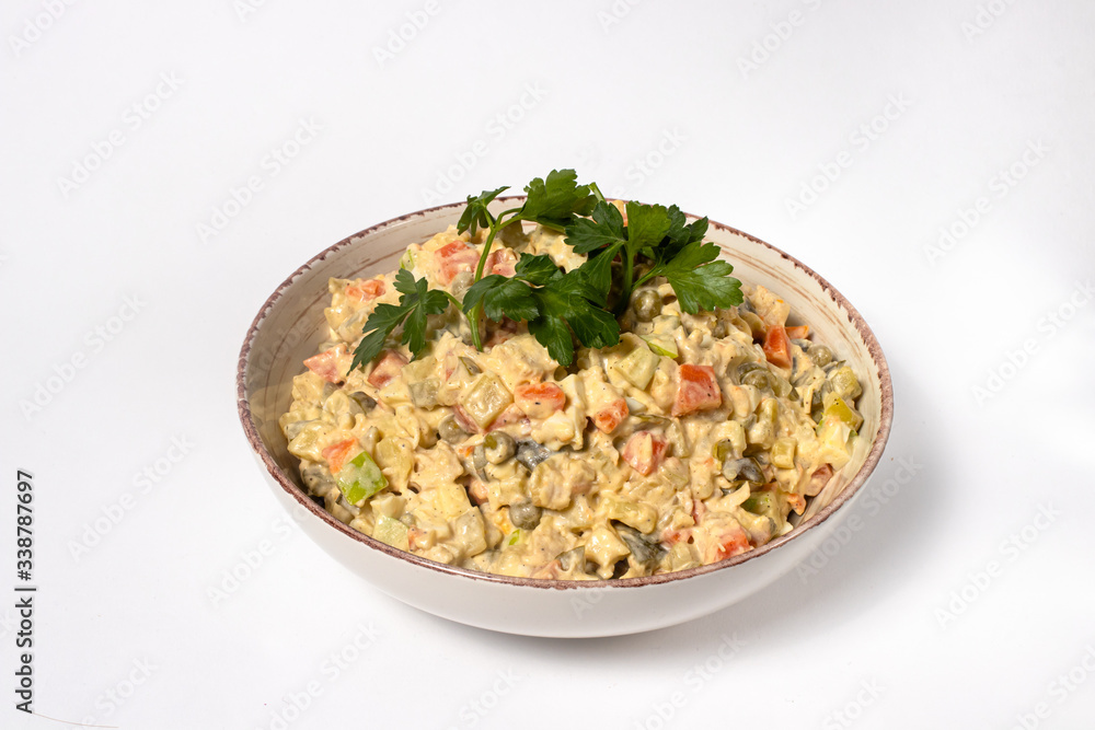 Olivier salad - a classic recipe with mayonnaise, an incredible taste. Olivier salad on a white background, homemade recipe. Olivier salad - a classic recipe with mayonnaise, an incredible taste. Olivier salad on a white background, homemade recipe.