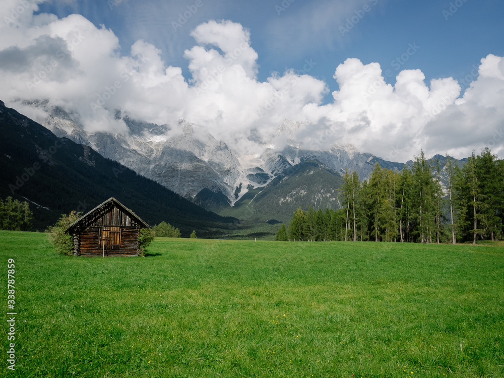 Wiese mit Hütte vor Berglandschaft in Tirol