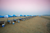 Bangladesh – February 22, 2020: Row of sunshade and deck chairs on Cox's Bazar Beach in Bangladesh.
