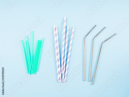 Different material drinking straws on pastel blue background - plastic  paper and eco friendly plastic free stainless steel reusable straws. Flat lay
