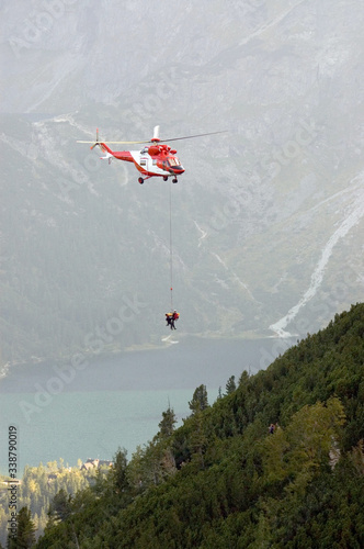 Ratownicy górscy ratujący turystę przy pomocy helikoptera w górach Tatrach