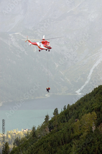 Ratownicy górscy ratujący turystę przy pomocy helikoptera w górach Tatrach photo