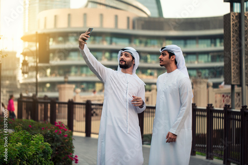 two Arab young men taking selfie in Dubai streets 