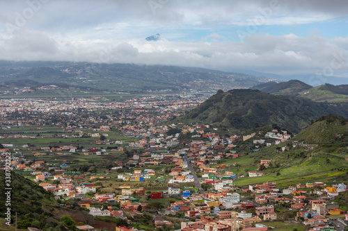 Landscape of a colorful town seen from a viewpoint in the mountain with green hills in Tenerife