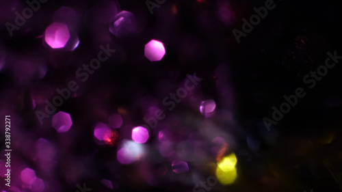 Dark Abstract violette bokeh sparkle on black background