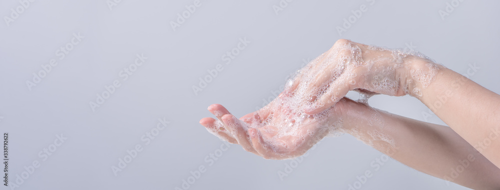 Washing hands. Asian young woman using liquid soap to wash hands, concept of hygiene to protective pandemic coronavirus isolated on gray white background, close up. Washing hands. Asian young woman using liquid soap to wash hands, concept of hygiene to protective pandemic coronavirus isolated on gray white background, close up.