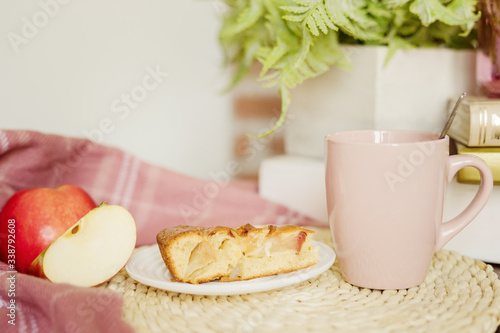 Fototapeta Naklejka Na Ścianę i Meble -  Apple pie, sliced apple and a cup of tea with milk on the table.