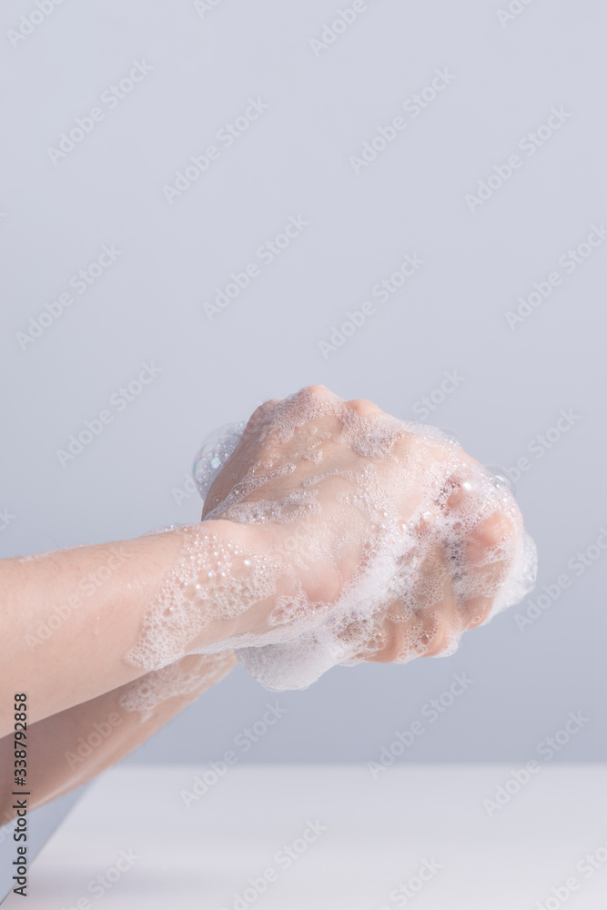 Washing hands. Asian young woman using liquid soap to wash hands, concept of hygiene to protective pandemic coronavirus isolated on gray white background, close up. Washing hands. Asian young woman using liquid soap to wash hands, concept of hygiene to protective pandemic coronavirus isolated on gray white background, close up.