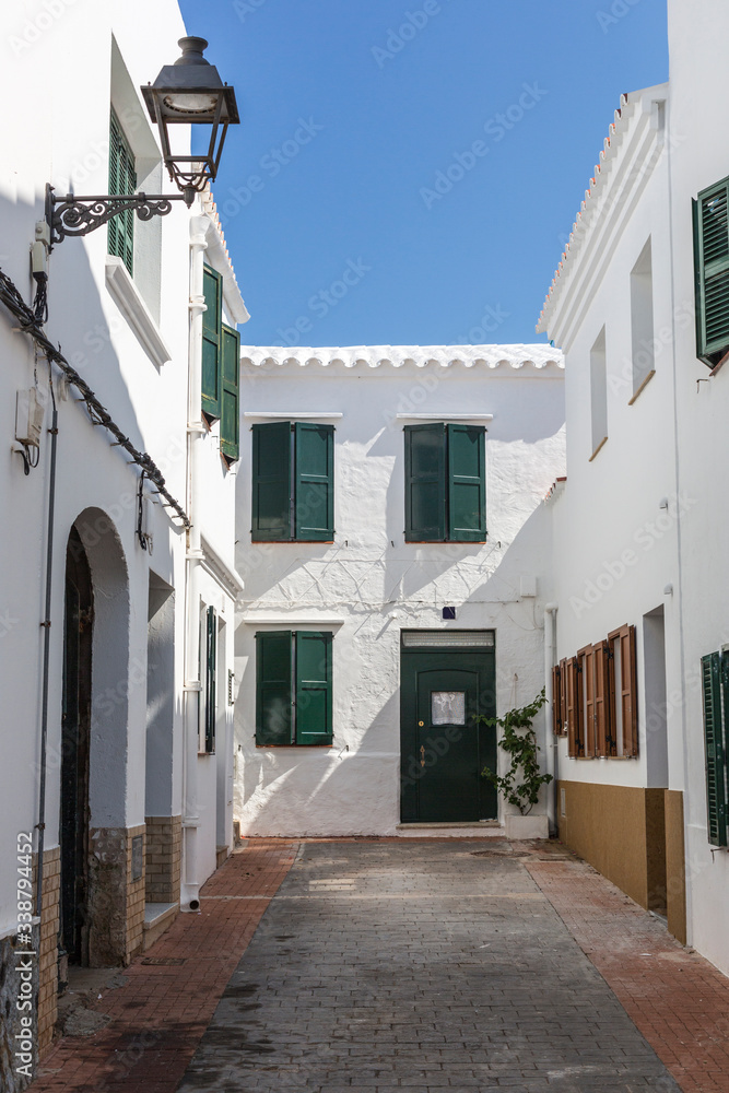Alley with white houses in Menorca, Balearic Islands, Spain