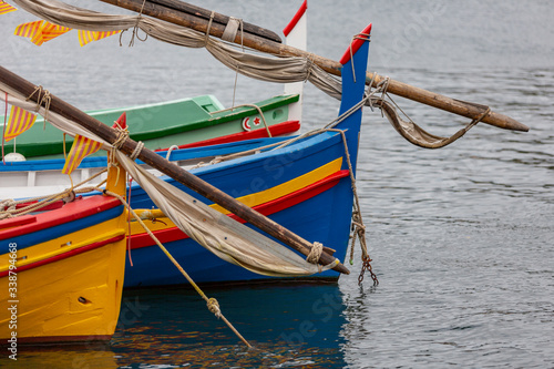 Detail of some multi colored wooden boats on the sea in a town of France