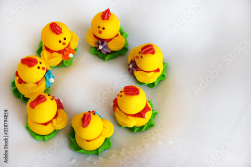 Easter minimalism concept, top view. Close up Group Easter chickens on white background. Yellow beautiful Easter decor of chickens on selective focus with copy space for text. © Iris_AN