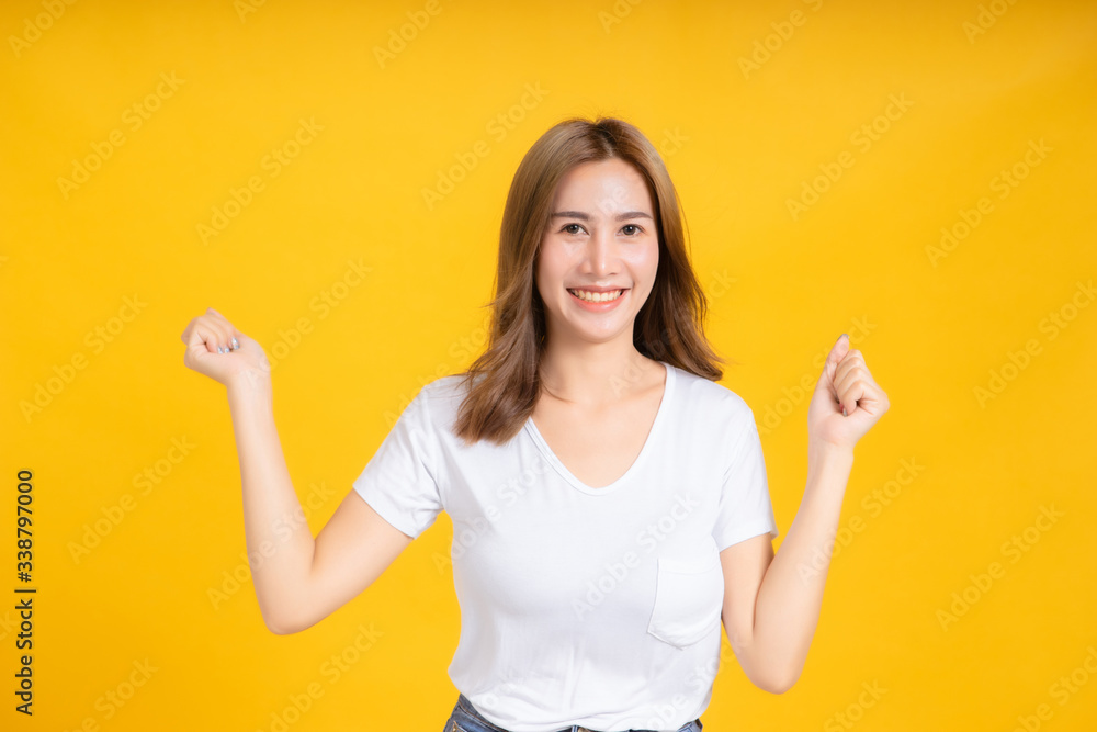 Portrait happy young asian woman dancing music celebrate fun enjoyment relaxation smiling positive emotion in white t-shirt, Yellow background isolated studio shot and copy space, party concept. Portrait happy young asian woman dancing music celebrate fun enjoyment relaxation smiling positive emotion in white t-shirt, Yellow background isolated studio shot and copy space, party concept.