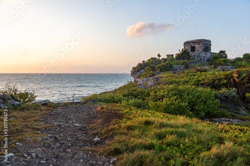 The wind temple in Tulum ruins, next to the cliffs, while the sun rises