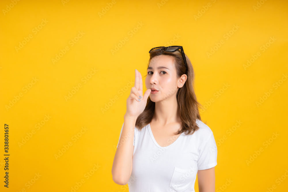 Portrait young asian woman gun shot hand gesture emotion killing business in white t-shirt, Yellow background isolated studio shot and copy space. Portrait young asian woman gun shot hand gesture emotion killing business in white t-shirt, Yellow background isolated studio shot and copy space.