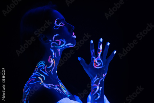 portrait of prayer woman with colorful fluorescent prints on skin, beautiful female pray, ask for blessing. prints glows in UV lights. body art, fantasy concept