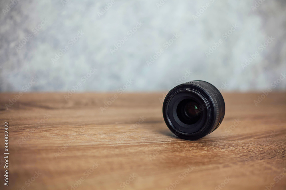 black lens lies sideways on a wooden background