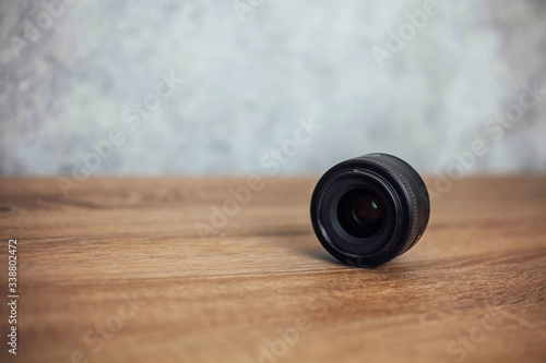 black lens lies sideways on a wooden background
