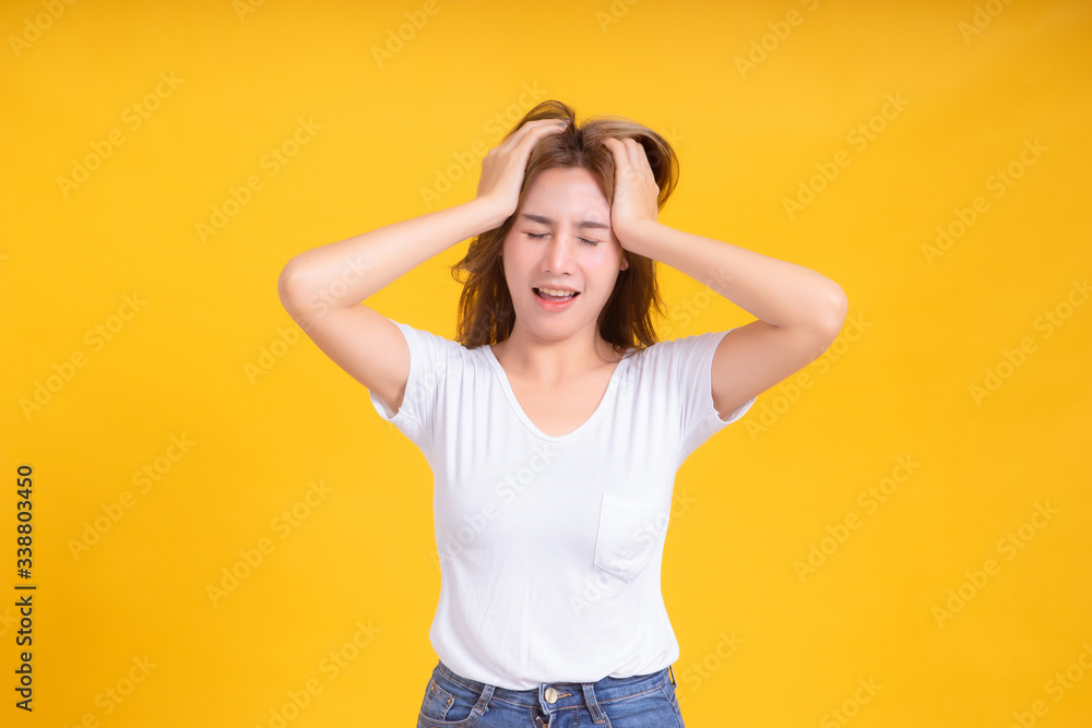 Portrait young asian woman stressed headache unhappy serious negative emotion in white t-shirt, Yellow background isolated studio shot and copy space. Portrait young asian woman stressed headache unhappy serious negative emotion in white t-shirt, Yellow background isolated studio shot and copy space.