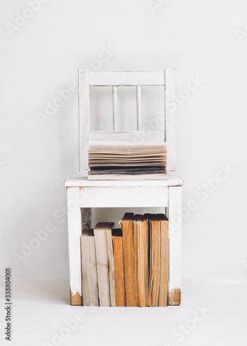 white chair in a room with books in the style of minimalism photo