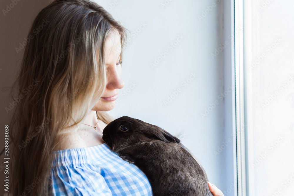 Pet and Easter concept - Happy girl hugging brown rabbit at home. Pet and Easter concept - Happy girl hugging brown rabbit at home.