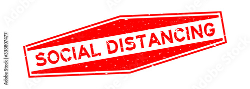 Grunge red social distancing word hexagon rubber seal stamp on white background