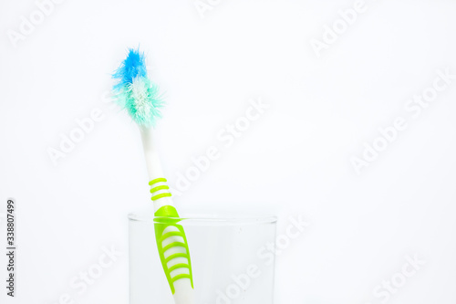 Old toothbrush  damaged  in clear glass for teeth cleaning isolated on white background - concept  How often should you change your toothbrush    