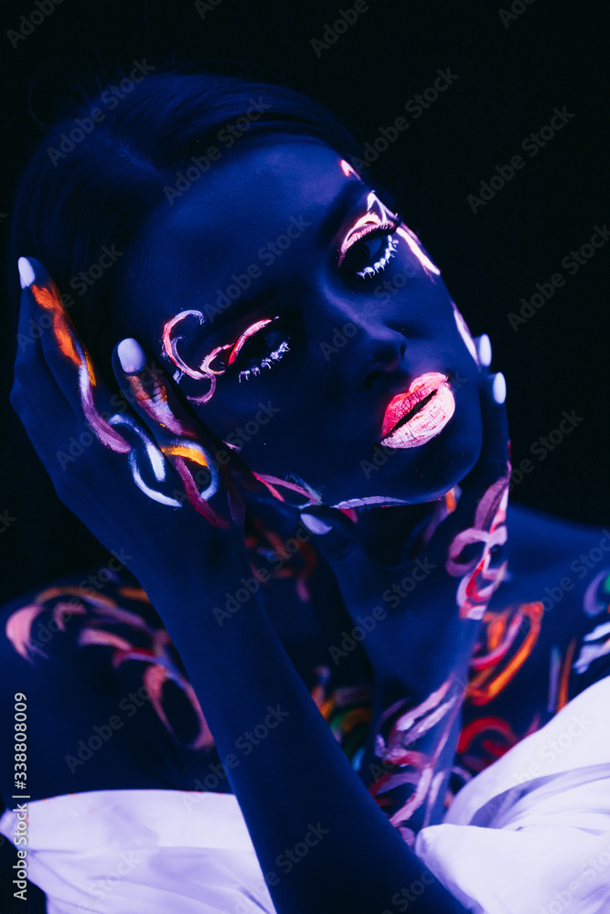 Φωτογραφία unusual modern shot of young caucasian woman with fluorescent body art, prints glows in ultra violet light