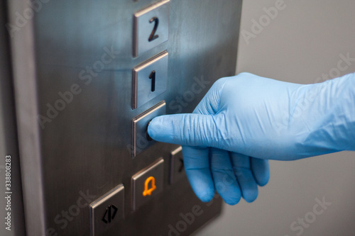 Przyciskanie przycisku w windzie ręka w rękawiczce
