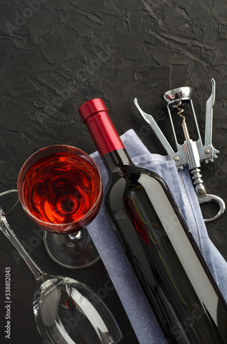 Bottle and glass with wine on dark background