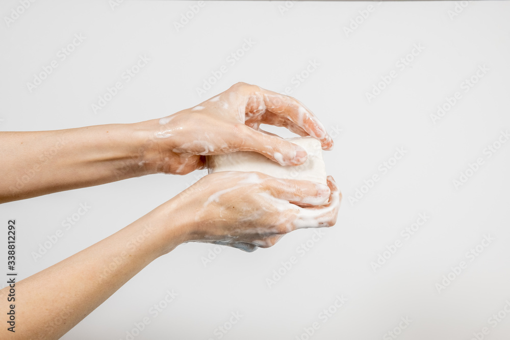 Caucasian woman washing her hands with bubbly soap bar isolated on white background Caucasian woman washing her hands with bubbly soap bar isolated on white background