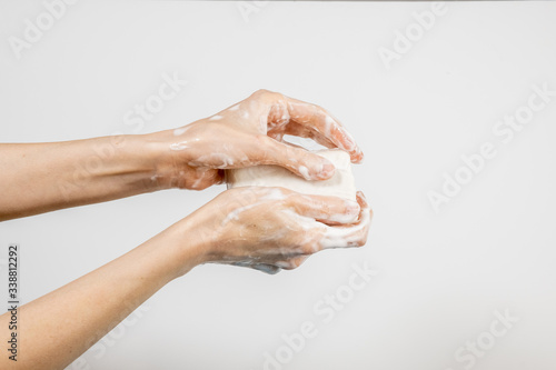 Caucasian woman washing her hands with bubbly soap bar isolated on white background