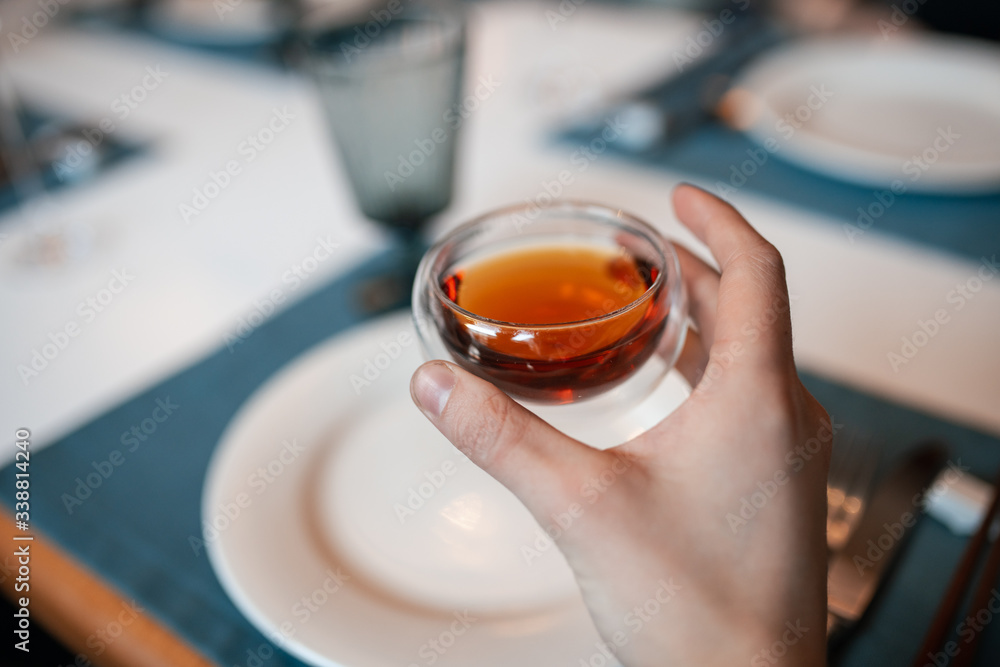 Girl drinks tea from a transparent bowl in a restaurant. Hand close-up Girl drinks tea from a transparent bowl in a restaurant. Hand close-up