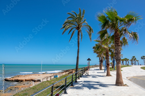 Beach walkway and palms in Cost Blanca, Spain.