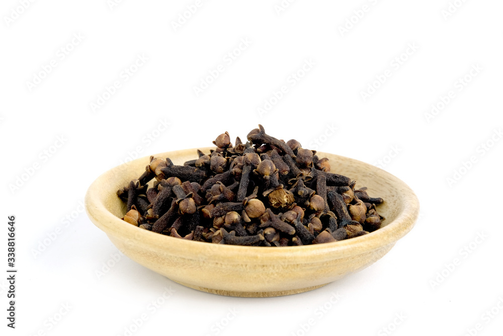 Closeup cloves on wooden bowl – isolated on white background Closeup cloves on wooden bowl – isolated on white background