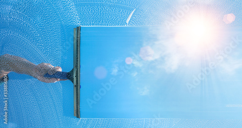 Obraz na płótnie window cleaner cleaning window with squeegee and wiper on a sunny day w salonie