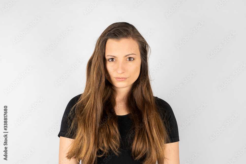 Young woman angry in black shirt with long hair Young woman angry in black shirt with long hair