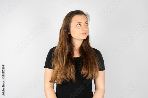 Young woman thinking in black shirt with long hair