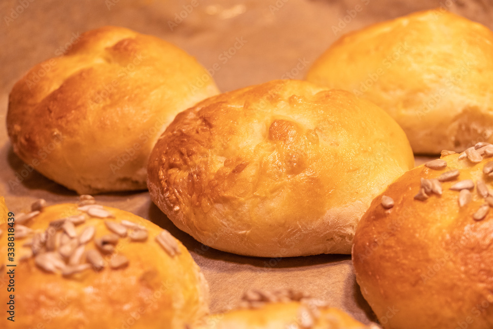 Home made bread rolls or buns for breakfast fresh on a paper on a table, selected focus, narrow depth of field