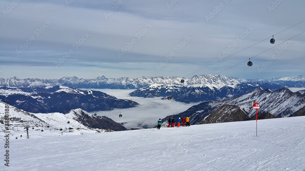 Austria sezon narciarski trasa narciarska widok z góry na dolinę pokrytą mgłą - obrazy, fototapety, plakaty 