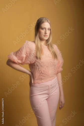 Vintage 1960s fashion woman in pink sweater and pants.