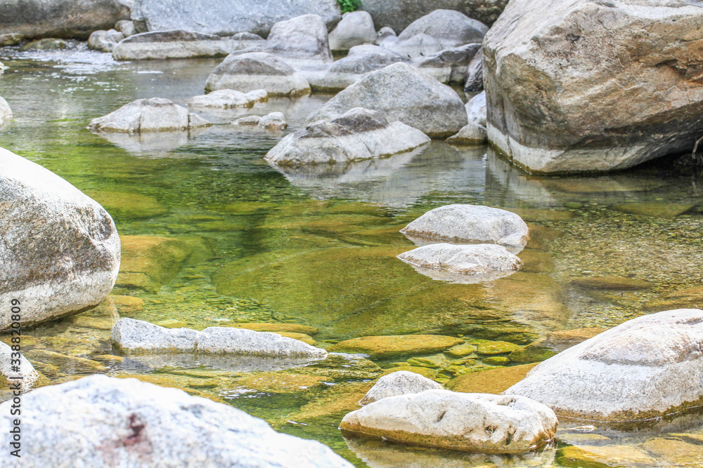 Close-up of crystal clear water with rocks at a natural river at Sardinia, Italy Close-up of crystal clear water with rocks at a natural river at Sardinia, Italy